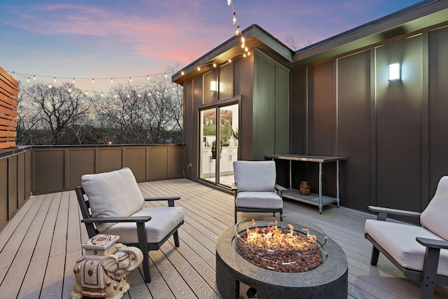 deck at dusk featuring french doors and a fire pit