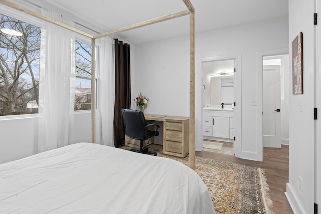 bedroom featuring ensuite bath and hardwood / wood-style floors