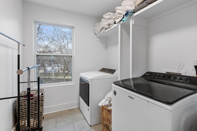 laundry room featuring separate washer and dryer, light tile patterned flooring, and plenty of natural light