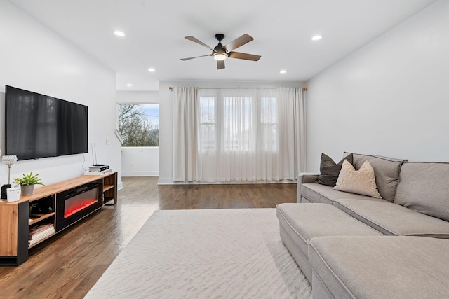 living room with ceiling fan and dark hardwood / wood-style floors