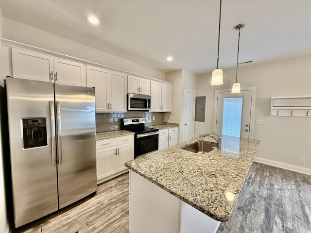 kitchen featuring white cabinetry, sink, appliances with stainless steel finishes, and an island with sink