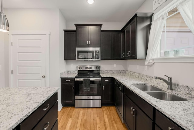 kitchen with appliances with stainless steel finishes, a healthy amount of sunlight, pendant lighting, and sink