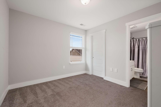 unfurnished bedroom featuring a spacious closet, a closet, carpet floors, and ensuite bath