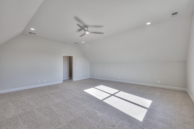 additional living space with ceiling fan, light colored carpet, and vaulted ceiling