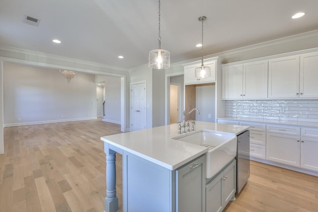 kitchen featuring dishwasher, white cabinetry, sink, and an island with sink