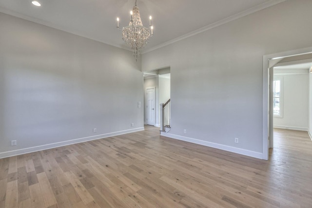 unfurnished room featuring crown molding, a chandelier, and light hardwood / wood-style floors