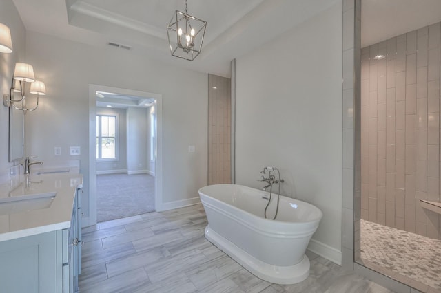 bathroom featuring vanity, separate shower and tub, ornamental molding, a tray ceiling, and a notable chandelier