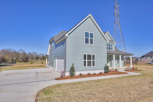 view of front facade featuring a porch, a garage, and a front lawn