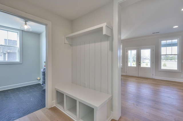 mudroom with french doors, light hardwood / wood-style floors, plenty of natural light, and ornamental molding