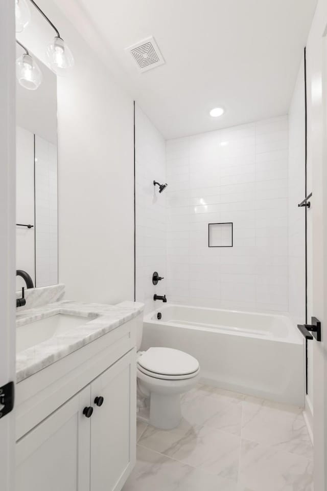 full bathroom with vanity, tiled shower / bath combo, and toilet