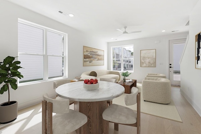 dining area with ceiling fan and light hardwood / wood-style flooring