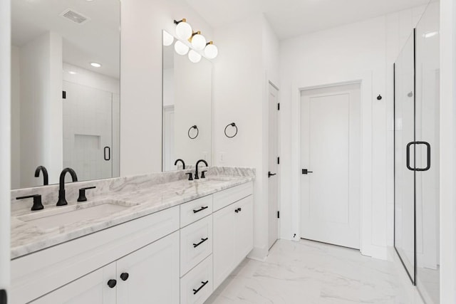 bathroom with a shower with door and vanity