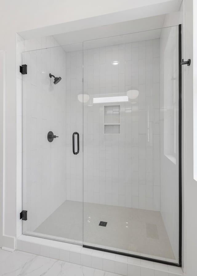 bathroom featuring a shower with door