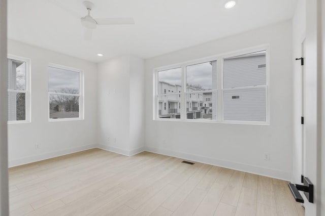 unfurnished room featuring a wealth of natural light, ceiling fan, and light hardwood / wood-style floors