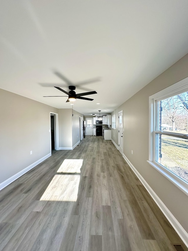 unfurnished living room featuring ceiling fan and light wood-type flooring