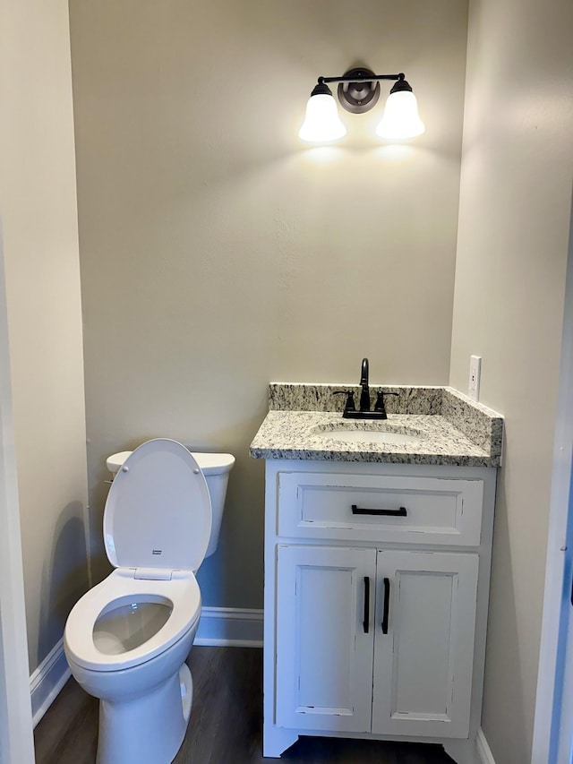 bathroom featuring wood-type flooring, vanity, and toilet