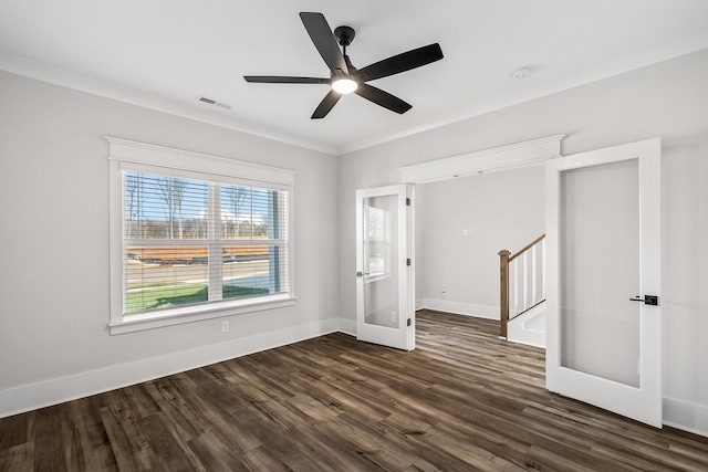 empty room featuring dark wood-type flooring, ceiling fan, crown molding, and french doors