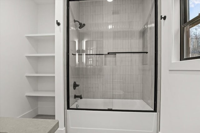 bathroom with vanity, combined bath / shower with glass door, and built in features