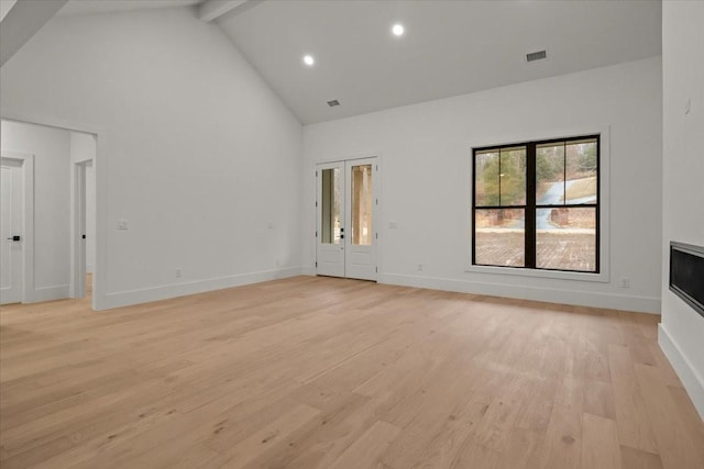 unfurnished living room featuring high vaulted ceiling, beam ceiling, and light hardwood / wood-style floors