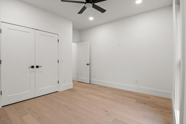 unfurnished bedroom featuring light hardwood / wood-style floors, a closet, and ceiling fan