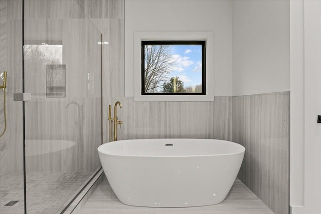 bathroom featuring separate shower and tub and tile walls