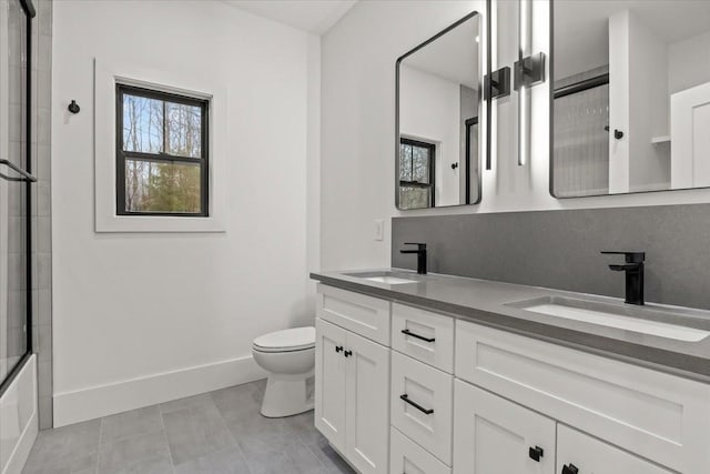 full bathroom featuring shower / bath combination with glass door, vanity, toilet, and tile patterned flooring