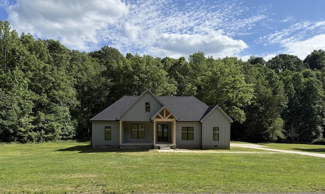 404 Rustling Oaks Dr, Waverly, TN 37185 - modern inspired farmhouse with crawl space, a front lawn, board and batten siding, and a view of trees