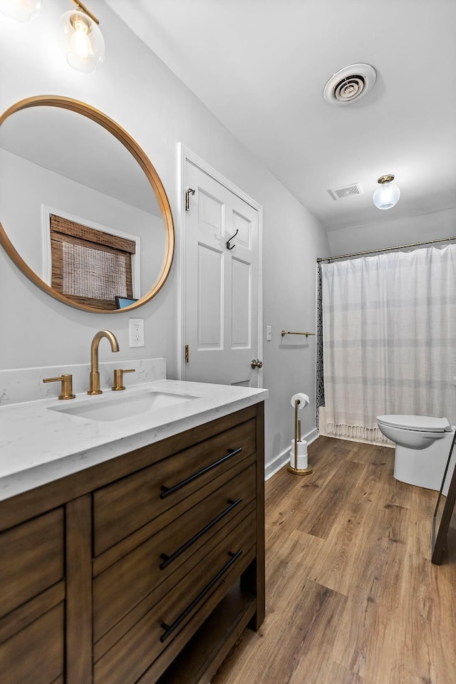 bathroom with toilet, vanity, a shower with shower curtain, and hardwood / wood-style flooring