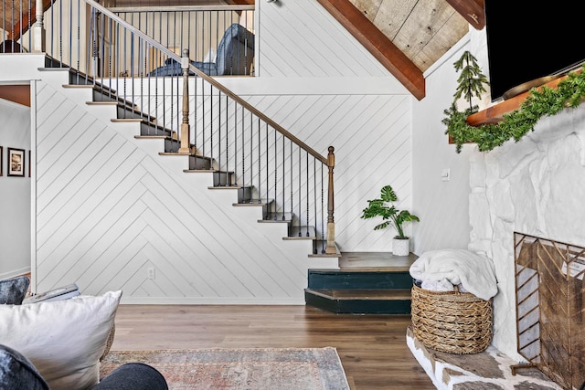 stairway with hardwood / wood-style floors, vaulted ceiling with beams, and wooden ceiling