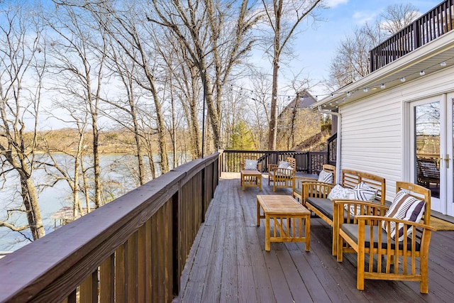 wooden terrace featuring outdoor lounge area and a water view