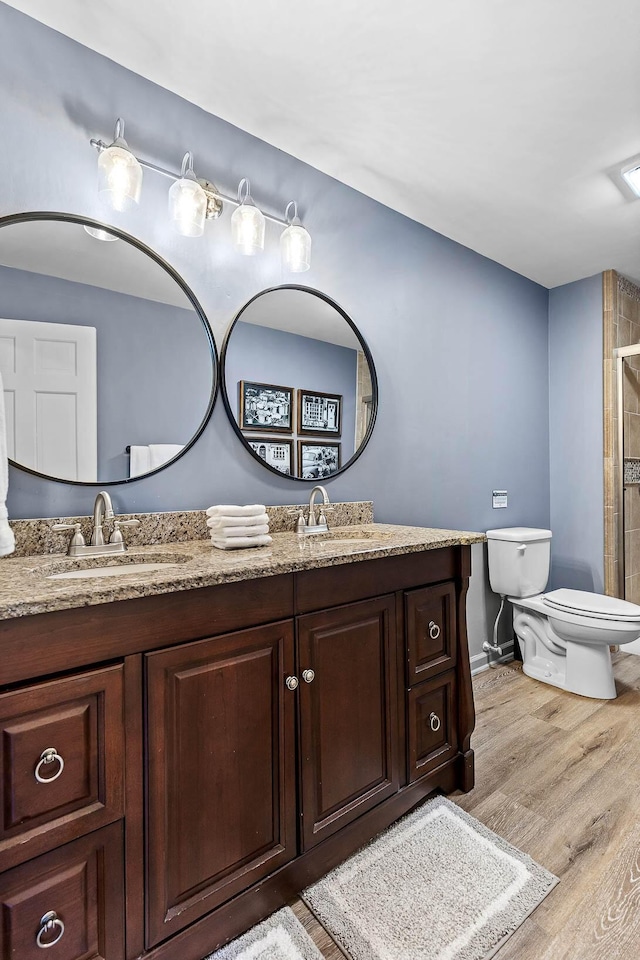 bathroom with hardwood / wood-style floors, vanity, and toilet