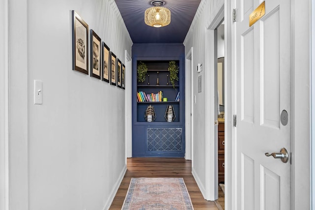 corridor with built in shelves and dark hardwood / wood-style flooring