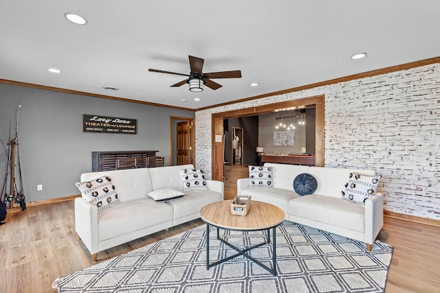 living room with crown molding, ceiling fan, and light wood-type flooring