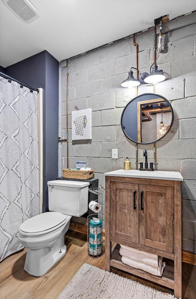 bathroom with toilet, vanity, a shower with shower curtain, and hardwood / wood-style flooring