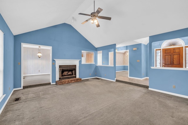 unfurnished living room featuring vaulted ceiling, carpet floors, a brick fireplace, and ceiling fan