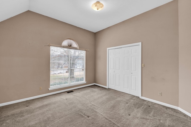 interior space with carpet flooring, a closet, and vaulted ceiling