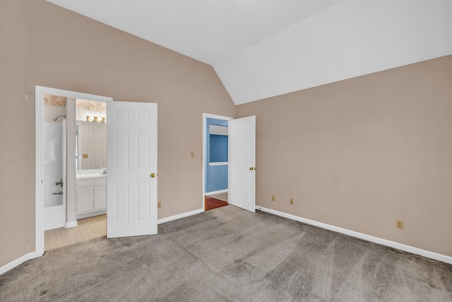 unfurnished bedroom featuring carpet, vaulted ceiling, and ensuite bath