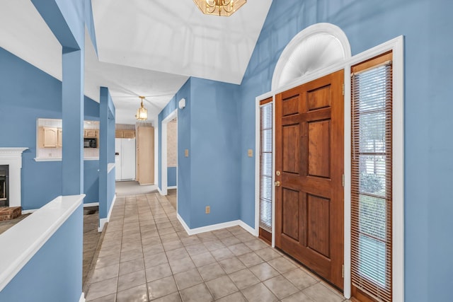 entrance foyer with vaulted ceiling, a healthy amount of sunlight, and light tile patterned flooring