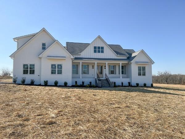 view of front of house featuring covered porch and a front lawn