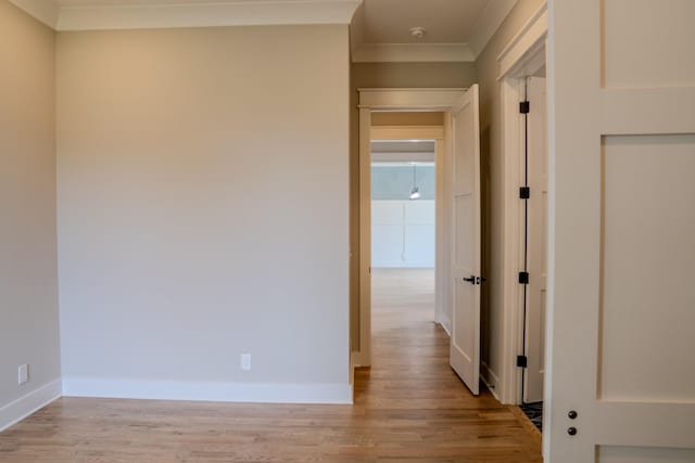 corridor featuring light wood-type flooring and ornamental molding