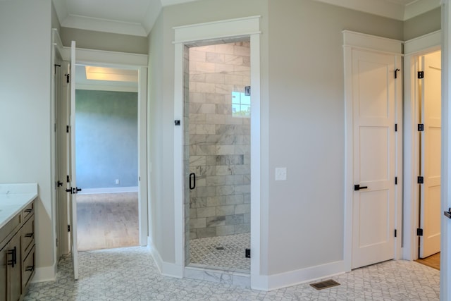 bathroom featuring vanity, an enclosed shower, and crown molding