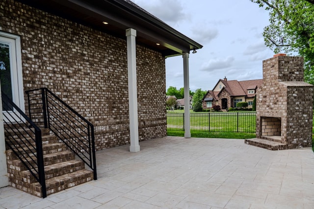 view of patio with an outdoor brick fireplace