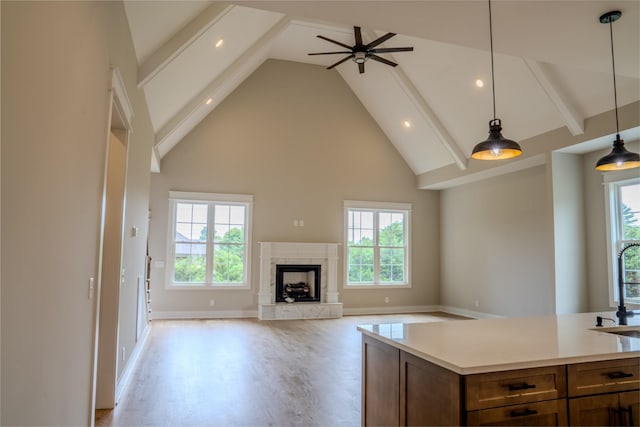 kitchen featuring a wealth of natural light, a fireplace, high vaulted ceiling, and hanging light fixtures