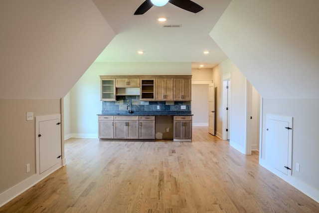 kitchen with tasteful backsplash, ceiling fan, light hardwood / wood-style flooring, and lofted ceiling