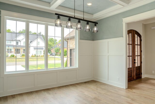 unfurnished dining area with ornamental molding, light hardwood / wood-style floors, coffered ceiling, and beam ceiling