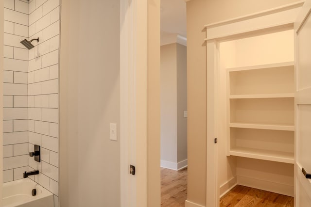 bathroom featuring hardwood / wood-style floors and tiled shower / bath