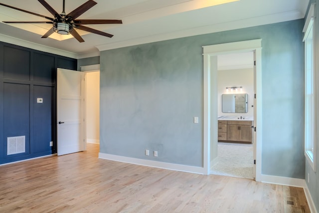 unfurnished bedroom with light hardwood / wood-style flooring, ensuite bath, ceiling fan, and crown molding