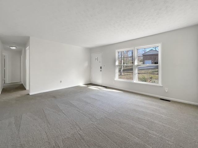 carpeted spare room featuring a textured ceiling