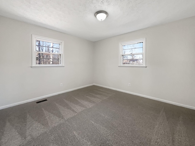 carpeted spare room with a textured ceiling