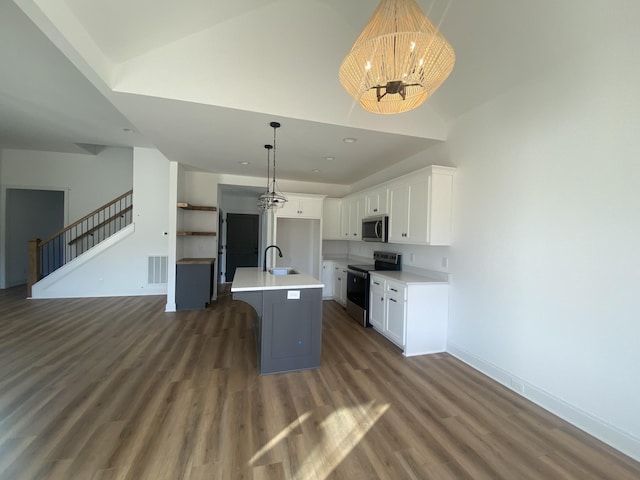 kitchen featuring white cabinetry, sink, stainless steel appliances, a chandelier, and a center island with sink